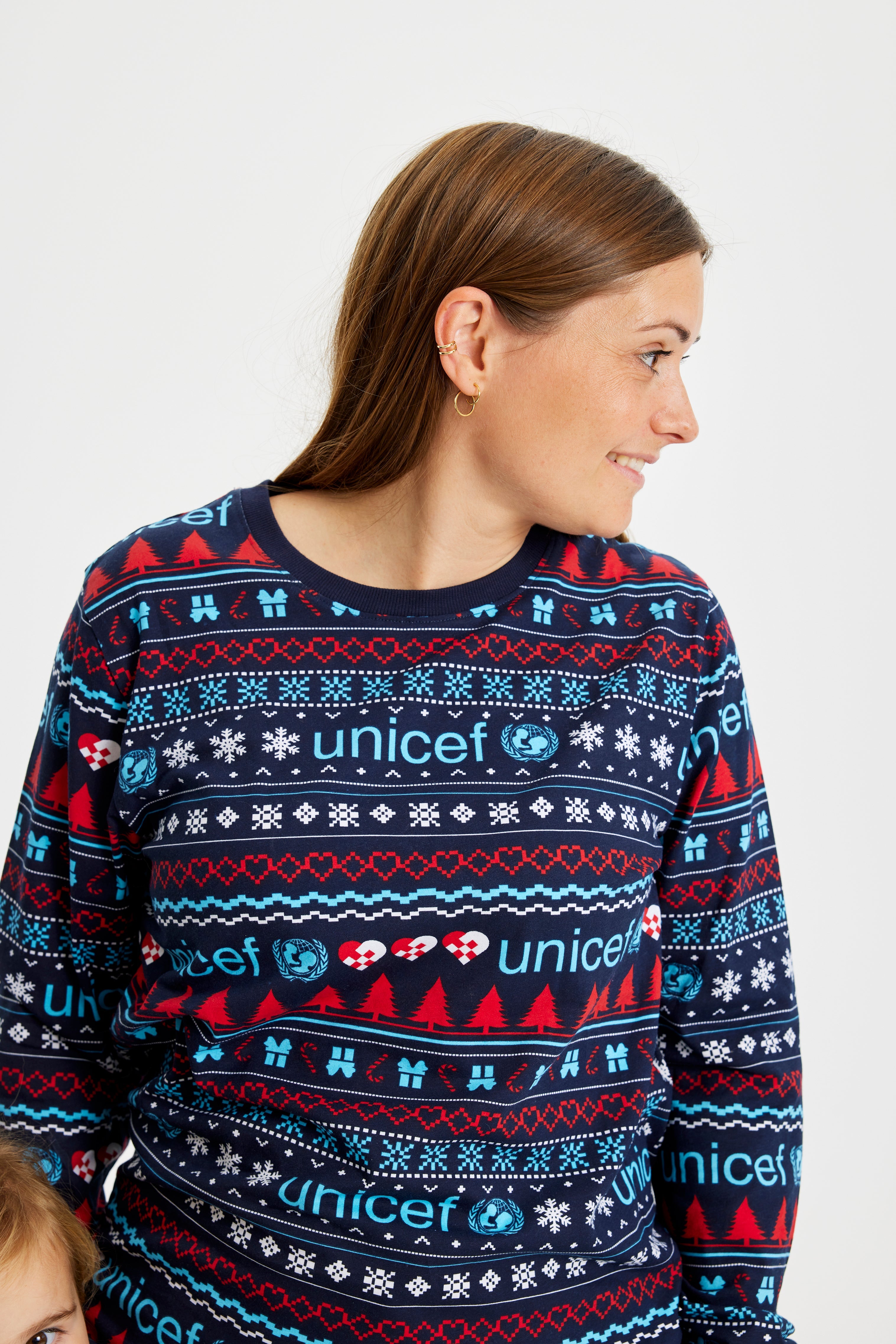 En dame kigger til siden mens hun er iført en julepyjamas med mønster på.